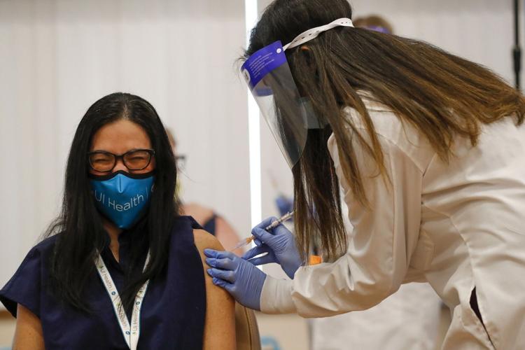 Dr Marina Del Rios reacts as she receives Chicago's first COVID-19 vaccination from Dr Nikhila Juvvadi on Dec 15, 2020.